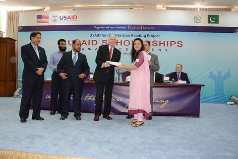 Gregory Gottlieb, Mission Director, United States Agency for International Development awards a scholarship cheque to a female recipient from IIUI.