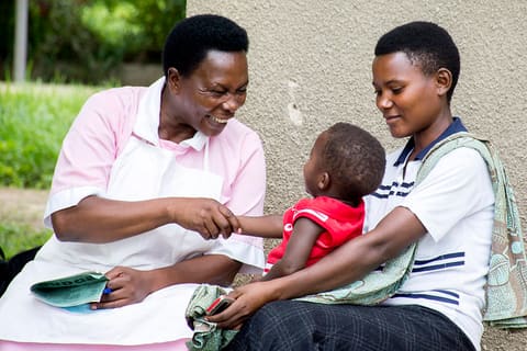 Nurse-midwife Dina congratulates Ignicius, who is graduating from the prevention of mother-to-child transmission of HIV (PMTCT) program
