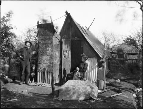 A man and woman outside a bush hut