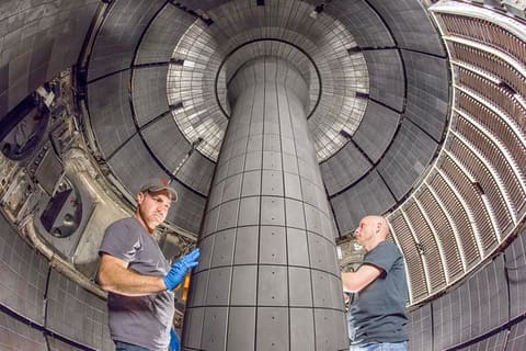 Technicians inside NSTXU vacuum vessel.