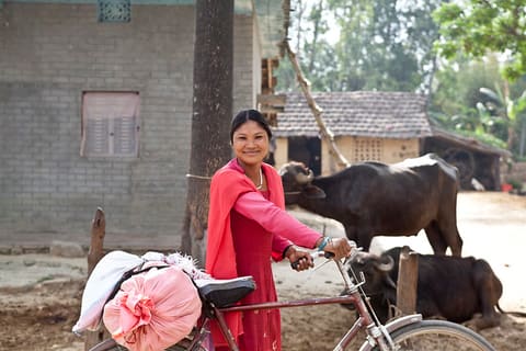 Ram Kumari Tharu, 33, heads out to a local collection center with her morning cucumber harvest. After extensive training on improved agriculture practices, her annual income has tripled in just two years.  She farms and grows enough to not only feed her f