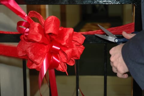 USAID Mission Director Jeff Borns cuts the ribbon at the re-opening of shelter for abused women and children
