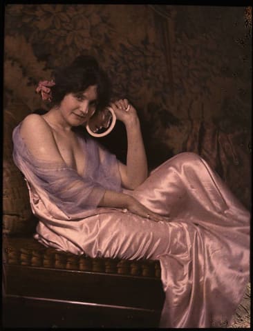 Woman in satin dress holding mirror