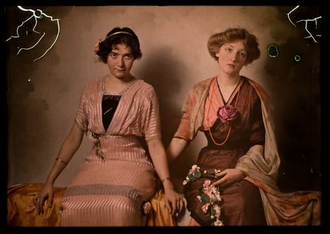 Two women seated on bench, interior