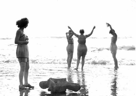 "Spruce Girls" in spruce veneer bathing suits at the beach playing in the surf, probably near Hoquiam, Washington
