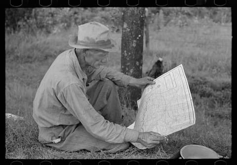White migrant agricultural worker from Texas studying the map while stopped for lunch on the roadside east of Fort Gibson, Oklahoma (LOC)