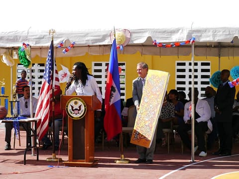 Local artist, Alexandre Joseph Mackley, presents a painting to USAID/Haiti Deputy Director, Steve Olive
